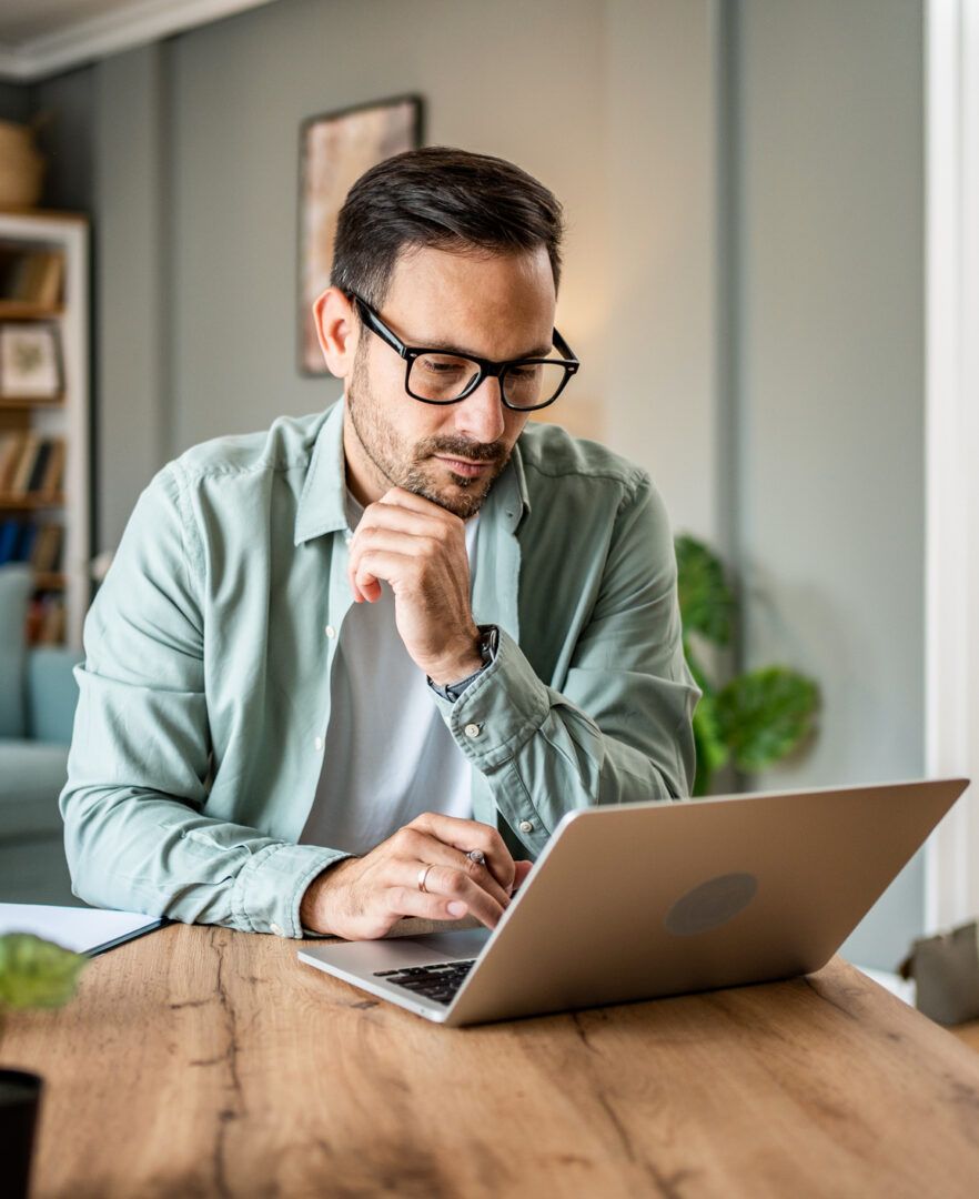 Portrait of handsome man looking at laptop