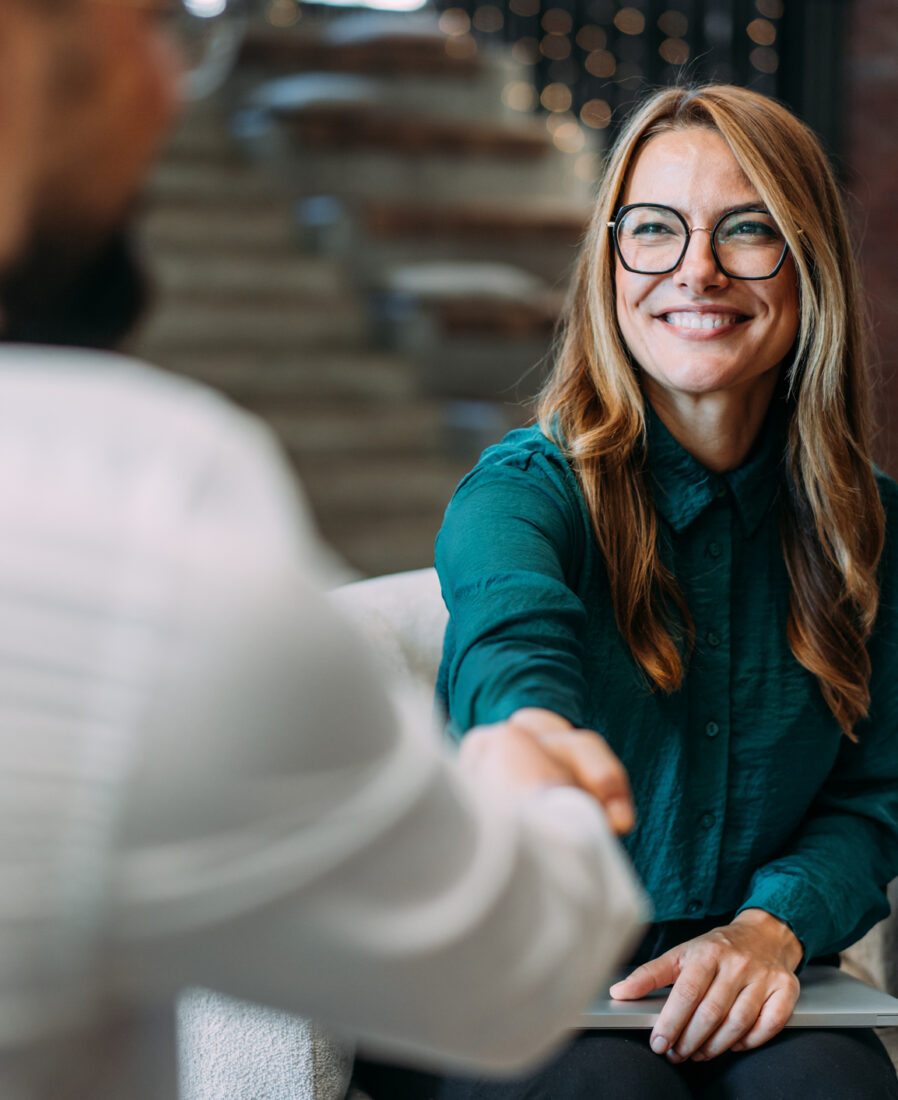 Business people shaking hands in the office. Business persons handshaking during a meeting in modern office.
