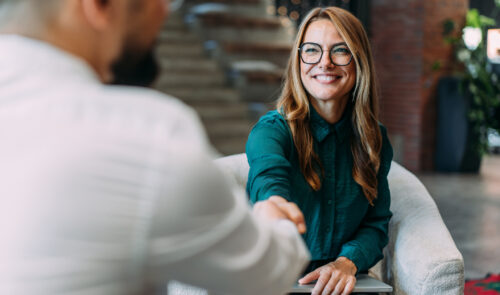 Business people shaking hands in the office. Business persons handshaking during a meeting in modern office.