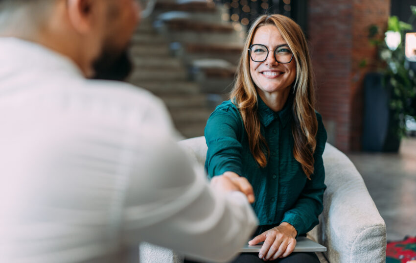 Business people shaking hands in the office. Business persons handshaking during a meeting in modern office.
